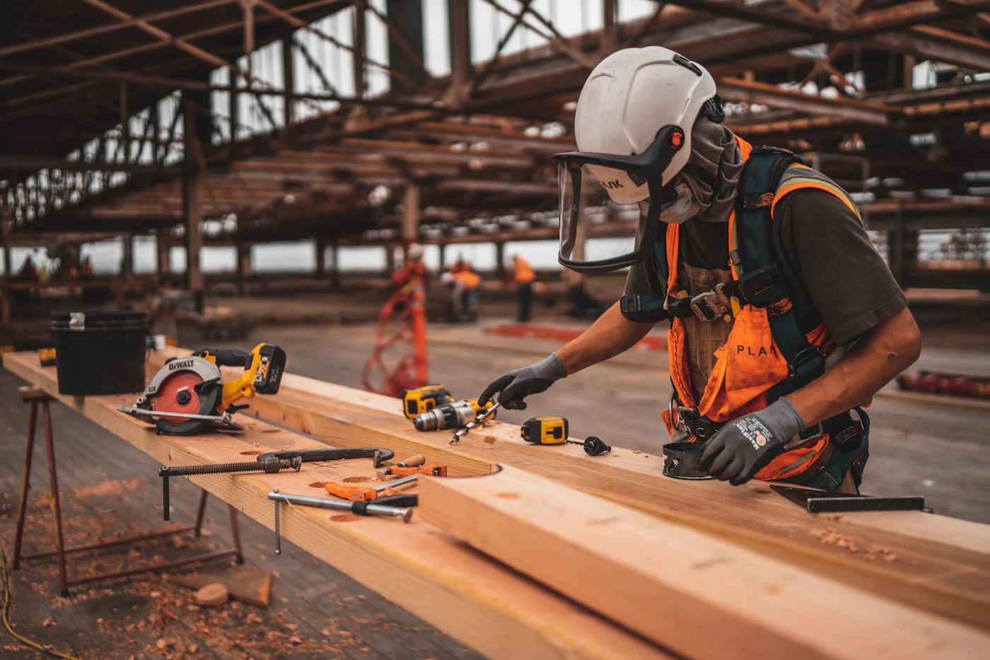 Carpenter measuring and cutting lumber on a job site